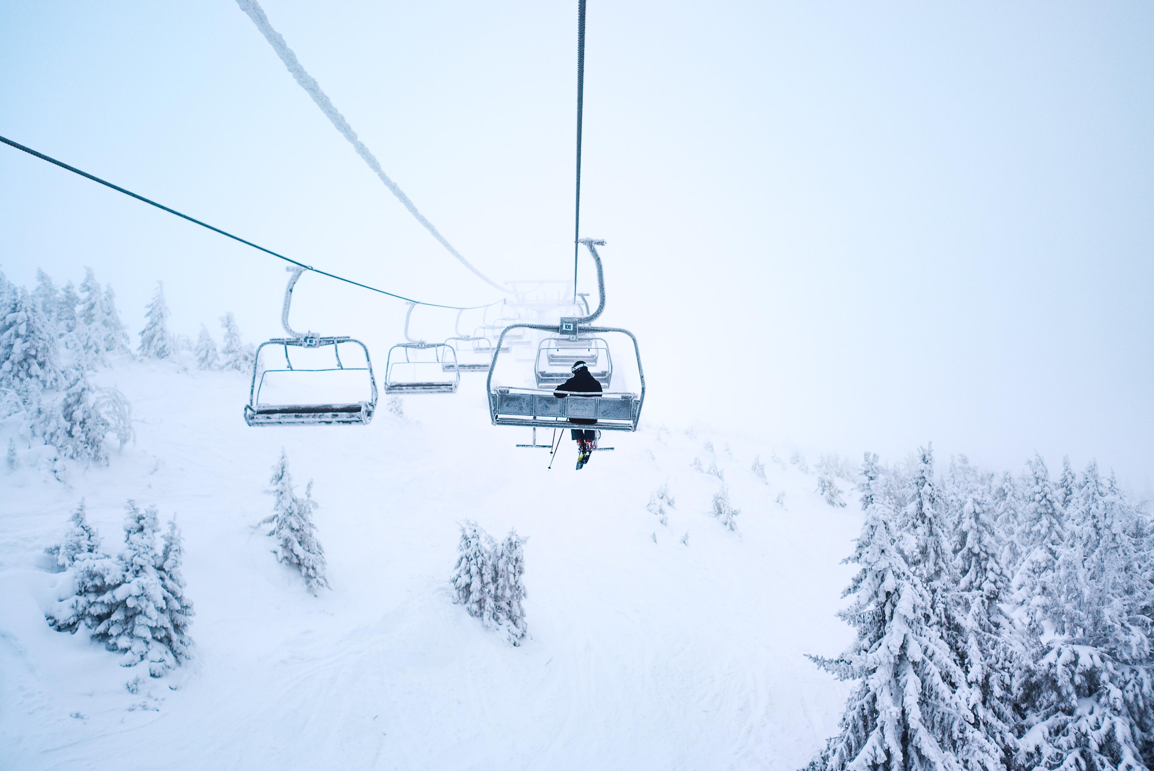 Snowy chair lift with a single skier on it in Norway