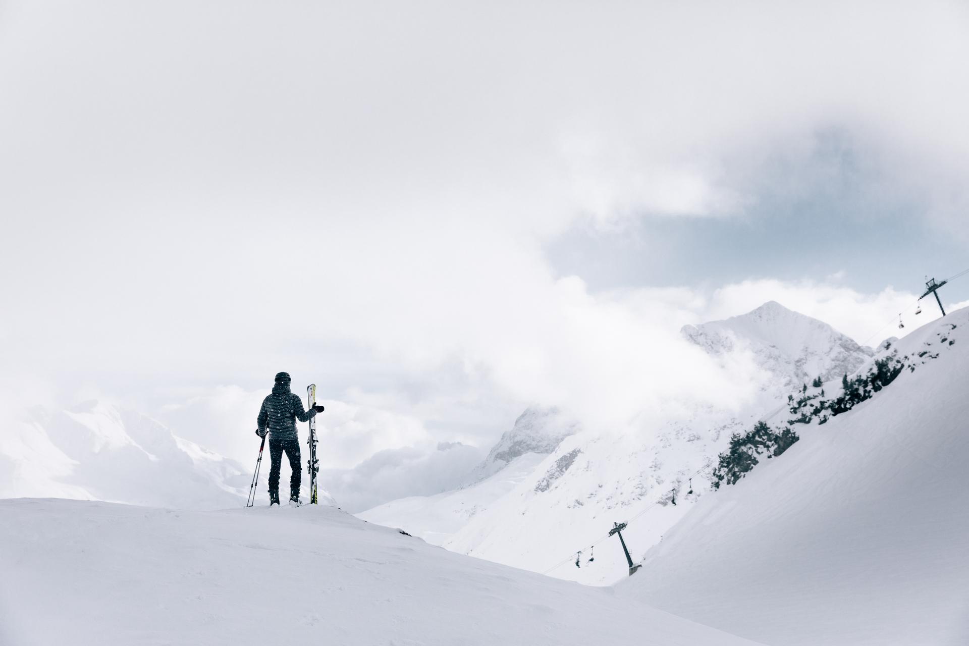 Skiier overlooking snowy mountain ski slopes